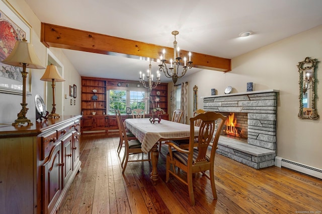 dining space with beam ceiling, wood-type flooring, baseboard heating, a notable chandelier, and a fireplace