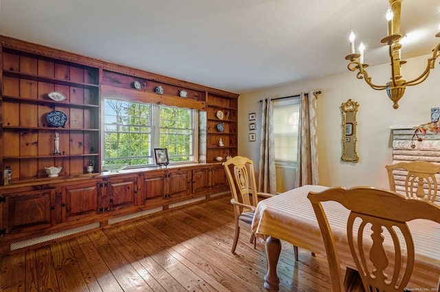 dining space with light hardwood / wood-style floors and a chandelier