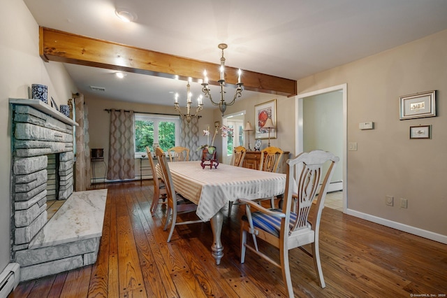 dining space with a stone fireplace, an inviting chandelier, a baseboard radiator, dark hardwood / wood-style flooring, and beamed ceiling