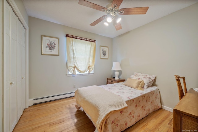 bedroom featuring a baseboard radiator, light wood-type flooring, ceiling fan, and a closet