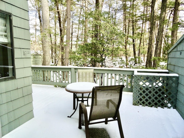 snow covered patio featuring a wooden deck