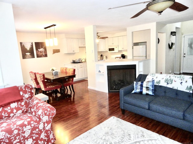 living room with dark wood-type flooring and ceiling fan