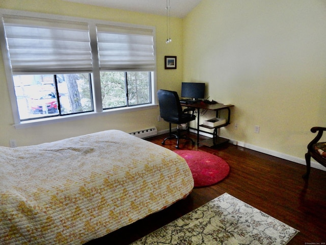 bedroom featuring a baseboard heating unit and hardwood / wood-style flooring