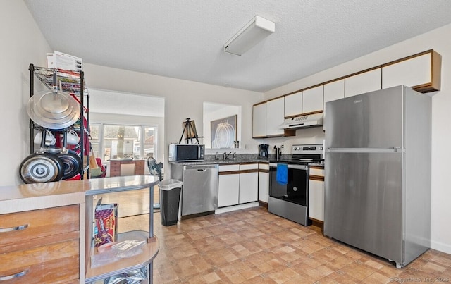 kitchen featuring appliances with stainless steel finishes, sink, white cabinets, and a textured ceiling