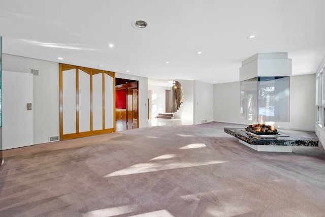 interior space with light carpet, stairs, visible vents, and recessed lighting