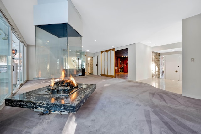 living room featuring carpet flooring, a high end fireplace, and baseboards