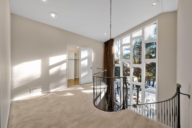 corridor with light carpet, an upstairs landing, and recessed lighting