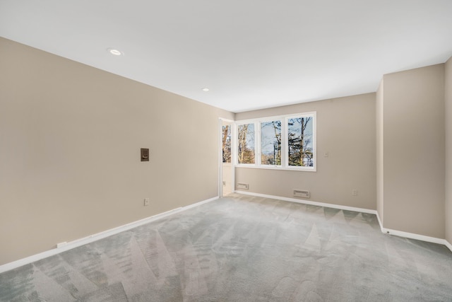 empty room featuring light carpet, baseboards, and recessed lighting