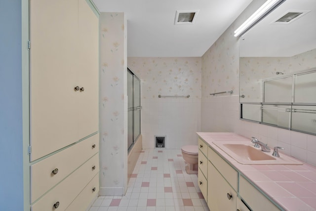 bathroom with wallpapered walls, visible vents, toilet, vanity, and tile walls