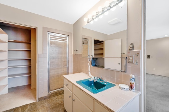 full bathroom featuring walk in shower, tile walls, and vanity