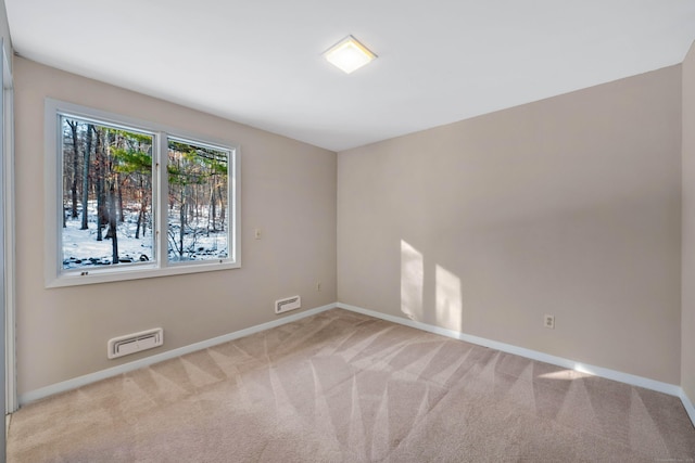 unfurnished room featuring light colored carpet, visible vents, and baseboards