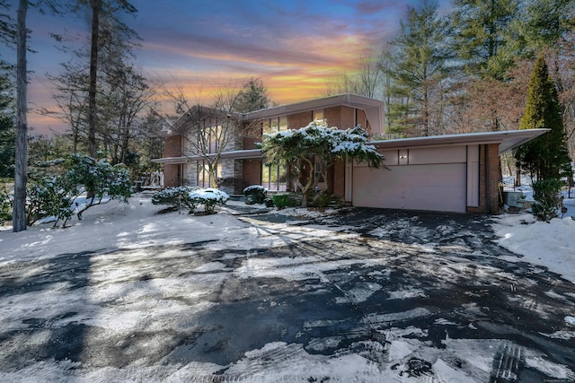 view of front facade featuring a garage, driveway, and brick siding