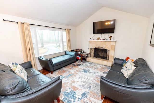 living room featuring hardwood / wood-style flooring, vaulted ceiling, and a fireplace