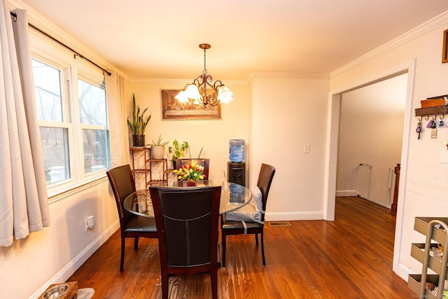 dining room featuring a notable chandelier, crown molding, and dark wood-type flooring