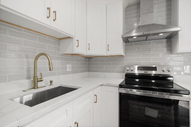 kitchen with electric stove, sink, white cabinetry, light stone countertops, and wall chimney exhaust hood