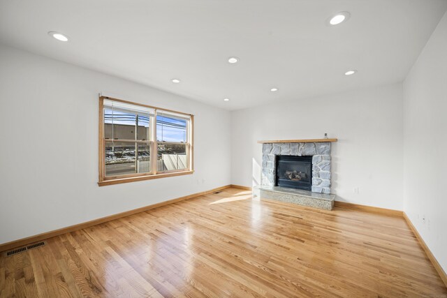 unfurnished living room with a fireplace and light hardwood / wood-style floors