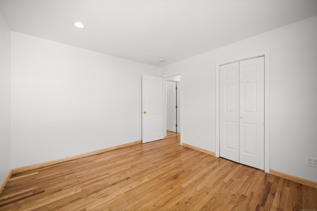 unfurnished bedroom featuring light hardwood / wood-style flooring and a closet