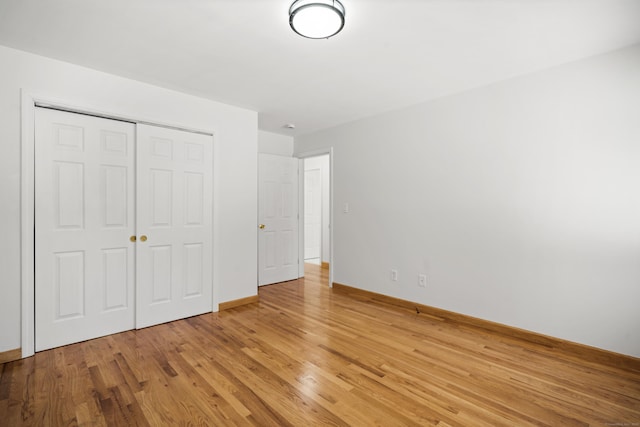 unfurnished bedroom featuring light hardwood / wood-style flooring and a closet