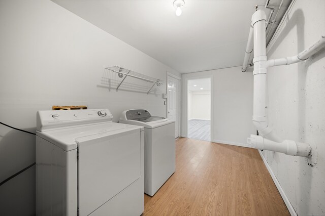 laundry room featuring washer and dryer and light wood-type flooring