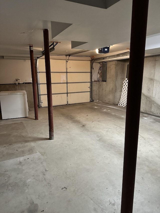 garage featuring a garage door opener, electric panel, and refrigerator