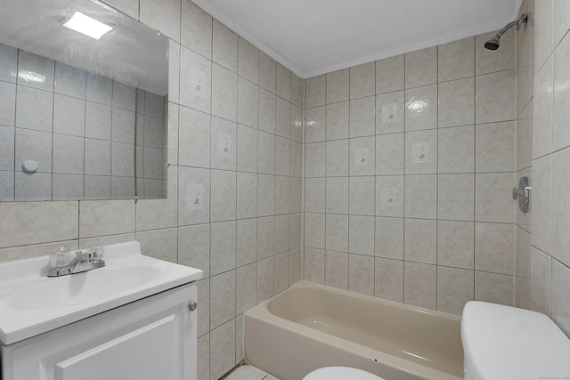 full bathroom featuring toilet, crown molding, tile walls, vanity, and tiled shower / bath combo