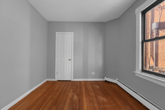 spare room featuring hardwood / wood-style flooring and a baseboard radiator