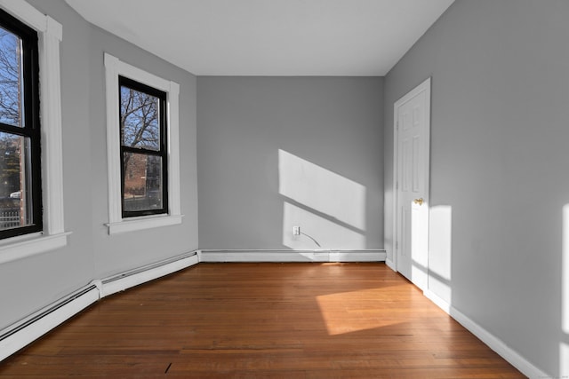 unfurnished room with hardwood / wood-style flooring, a baseboard radiator, and a healthy amount of sunlight