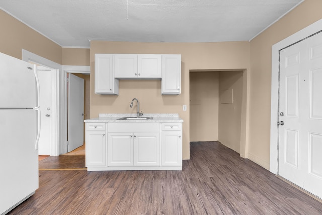 kitchen with dark hardwood / wood-style flooring, sink, white cabinets, and white refrigerator