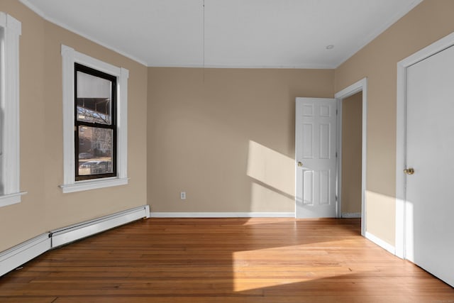 unfurnished room with light wood-type flooring and baseboard heating