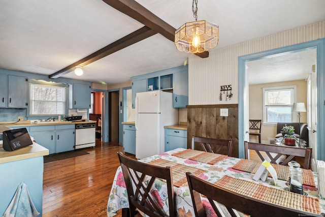 dining space featuring beamed ceiling, a healthy amount of sunlight, and dark hardwood / wood-style floors