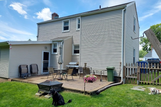 rear view of house with a yard, a patio area, and a fire pit