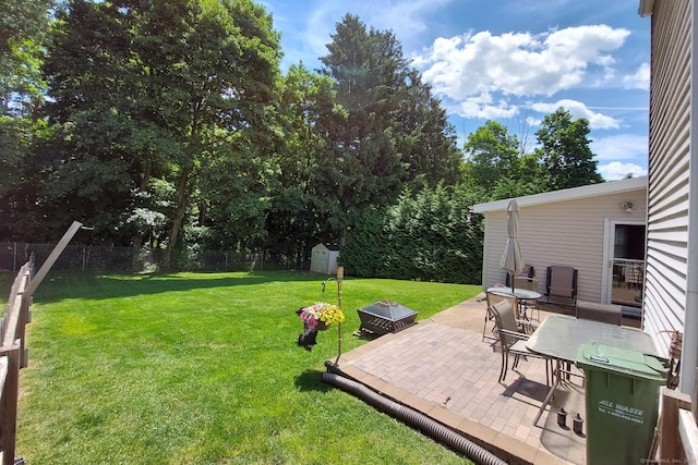 view of yard featuring an outdoor fire pit, a patio area, and a shed