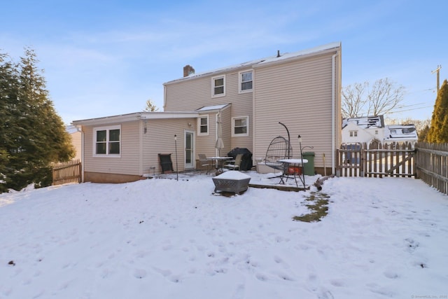 snow covered house featuring a fire pit