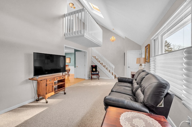 living room featuring light colored carpet, a skylight, and high vaulted ceiling