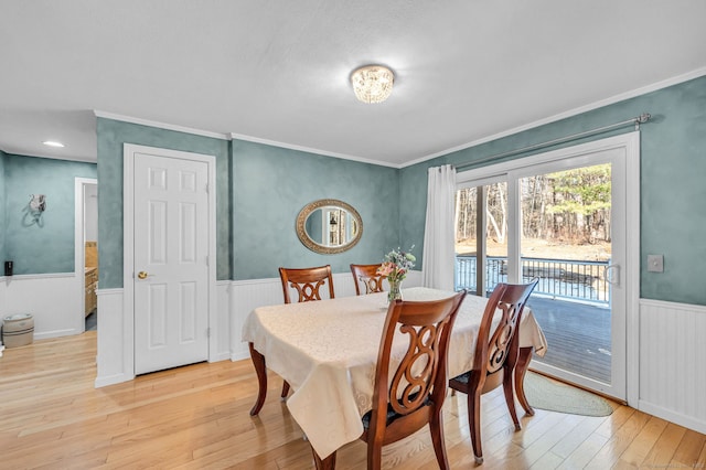 dining area with ornamental molding and light hardwood / wood-style flooring