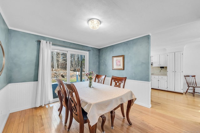 dining room featuring crown molding and light wood-type flooring