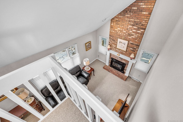 living room with lofted ceiling, carpet flooring, and a fireplace