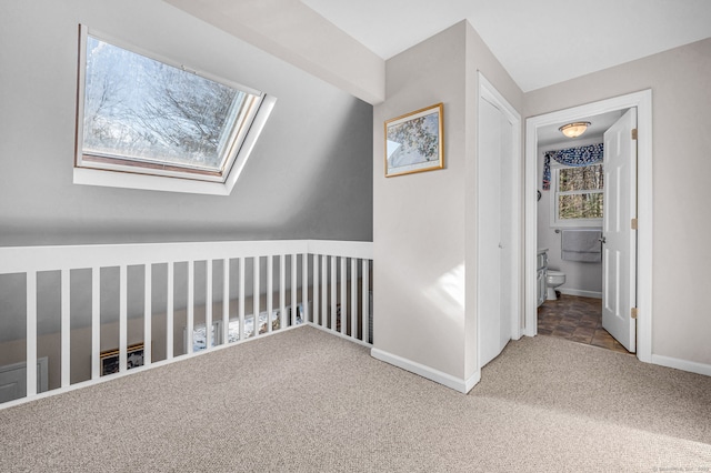 hallway featuring carpet flooring and a skylight