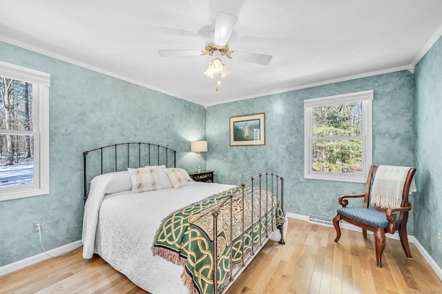 bedroom featuring hardwood / wood-style flooring, ceiling fan, and ornamental molding