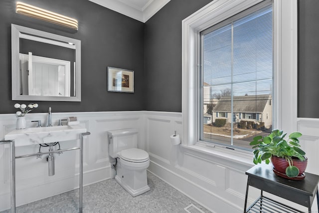 bathroom featuring crown molding and toilet