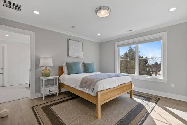 bedroom featuring crown molding and light wood-type flooring