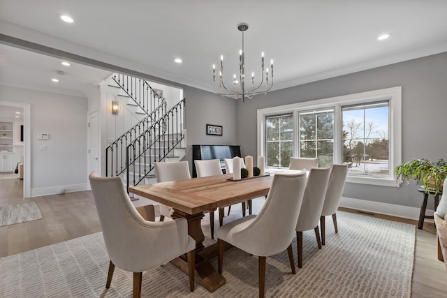 dining room with ornamental molding, a chandelier, and light hardwood / wood-style floors