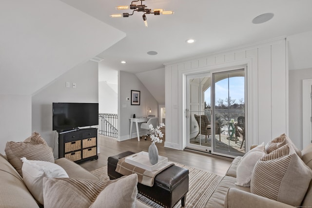 living room featuring lofted ceiling, a chandelier, and hardwood / wood-style floors