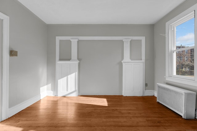 unfurnished living room with hardwood / wood-style flooring and radiator