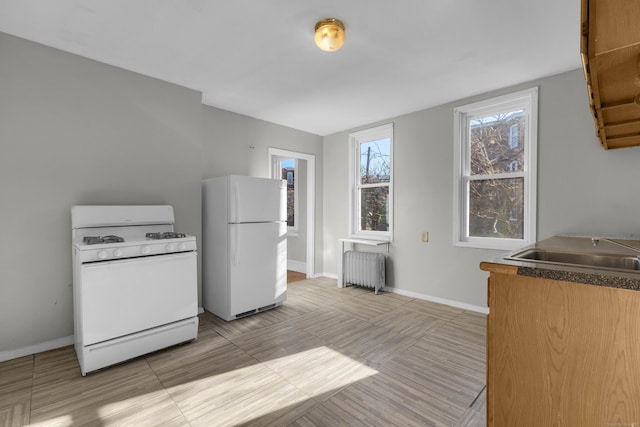 kitchen featuring white appliances and radiator heating unit