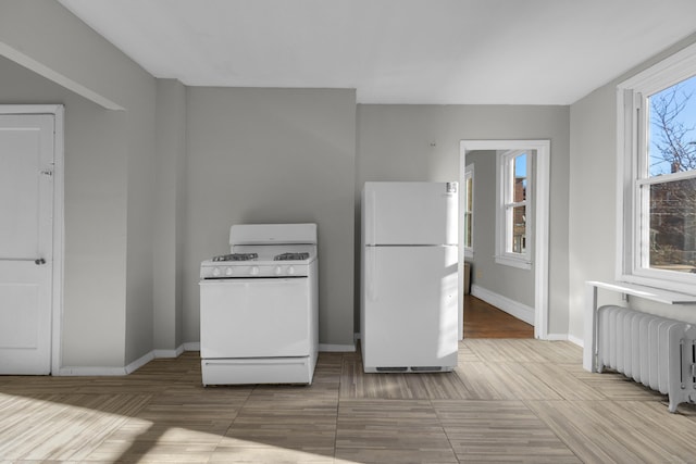 kitchen featuring radiator and white appliances