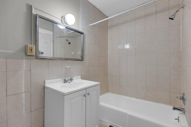 bathroom with tiled shower / bath, tile walls, vanity, and decorative backsplash