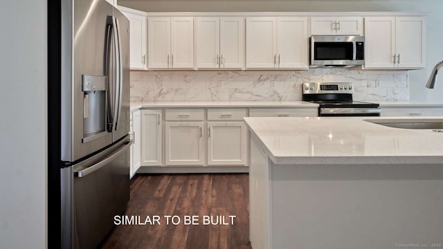 kitchen with sink, light stone counters, tasteful backsplash, appliances with stainless steel finishes, and white cabinets