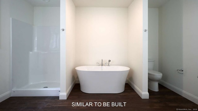 bathroom featuring toilet, wood-type flooring, and a tub to relax in