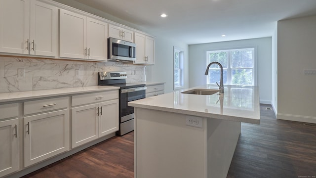 kitchen featuring dark wood-style floors, stainless steel appliances, a sink, and decorative backsplash